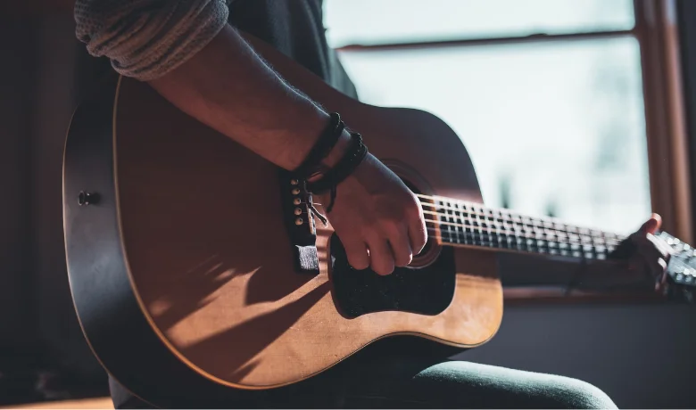 Homem segurando um violão