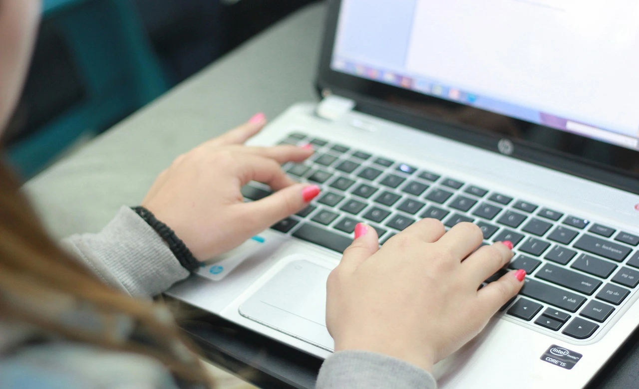 Foto seorang wanita sedang mengetik di laptop